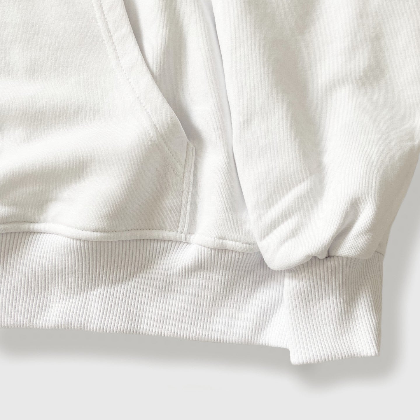 Close up of ribbed sleeve detail on 100% cotton white oversized hoodie.
