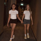 Two girls holding hands walking in a hotel hallway.