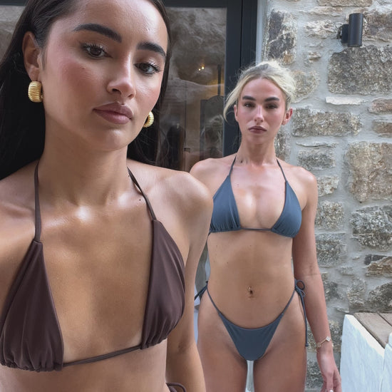 Models wearing dark brown bikini and navy blue string bikini.