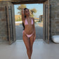 Model in light pink tie string bikini stood outside during golden hour.